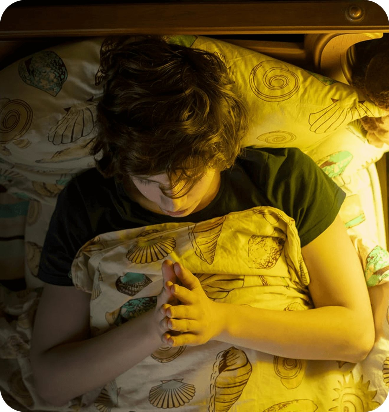 A child curled up in bed, avoiding the school morning