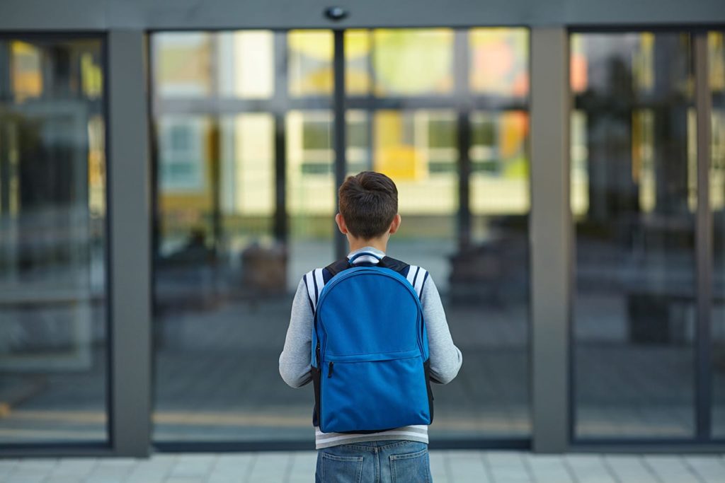 Boy in front of school
