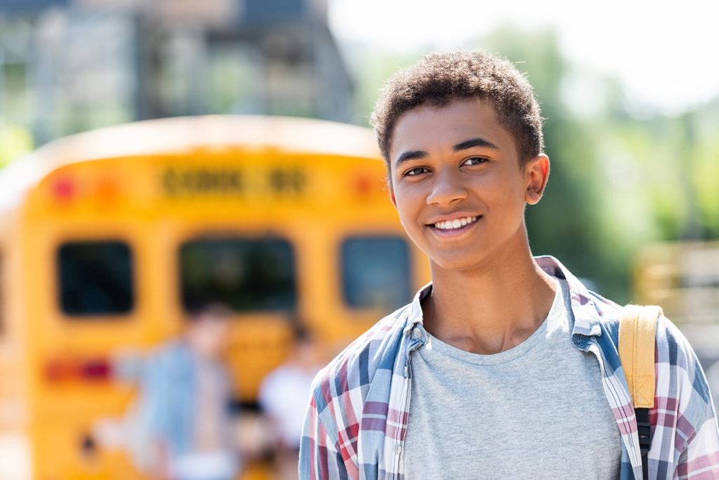 Boy in front of school bus